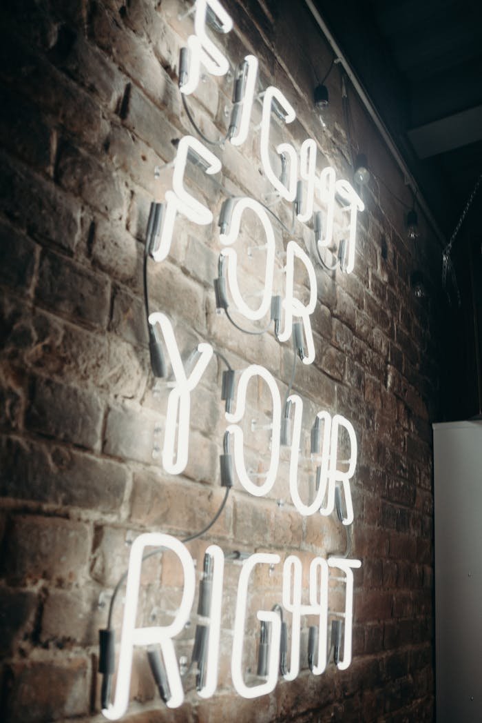 Neon light on brick wall displaying the phrase 'Fight For Your Right' offering a motivational message.